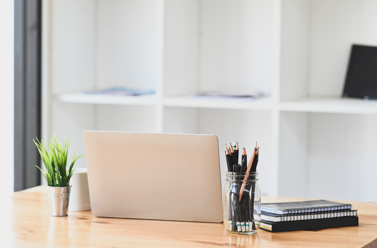 Aufgeräumter Holzschreibtisch mit Laptop, Notizbuch und Pflanze, Online-Workshop Aufgeräumter Schreibtisch – aufgeräumtes Leben